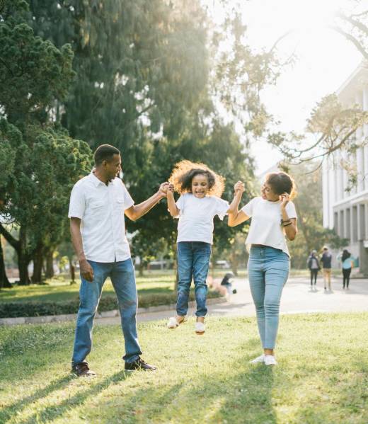 Joyful family enjoying a playful day at the park, embracing love and togetherness under the summer sun.