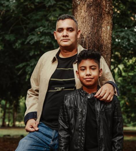 A father and son share a warm moment outdoors, symbolizing family bonding and love.